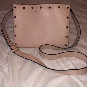 Cross body flat purse in light pink.